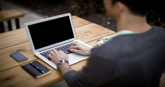 self-employed worker calculating taxes in front of a computer in a cafe