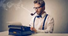 Escritor fumando en pipa delante de su máquina de escribir
