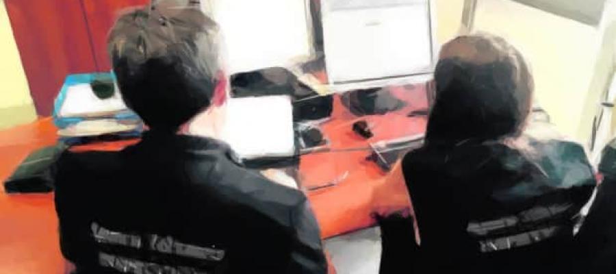 Dos Inspectores analizando los datos de una pantalla de ordenador